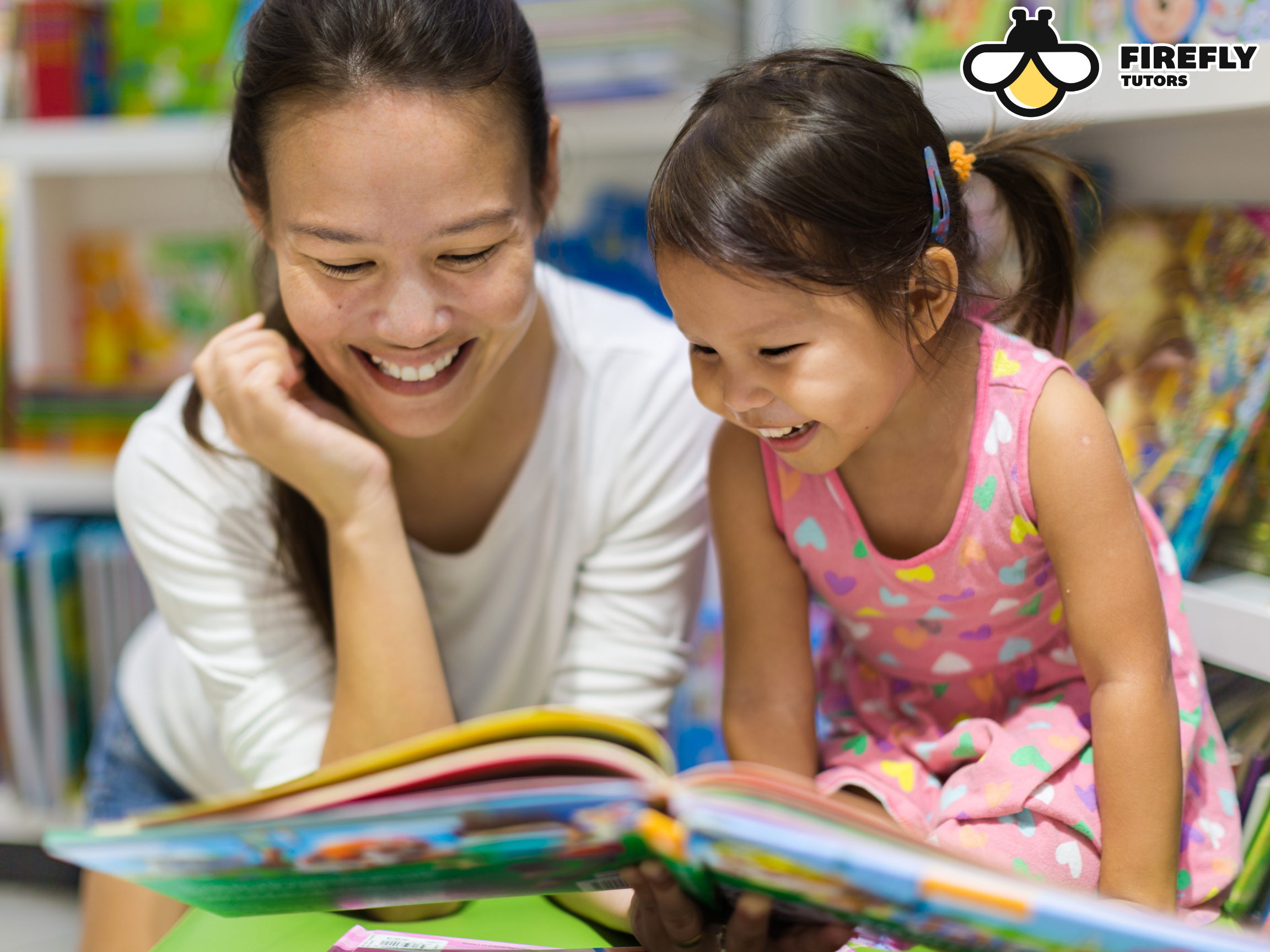 Parent and young child smiling while reading a colorful picture book together