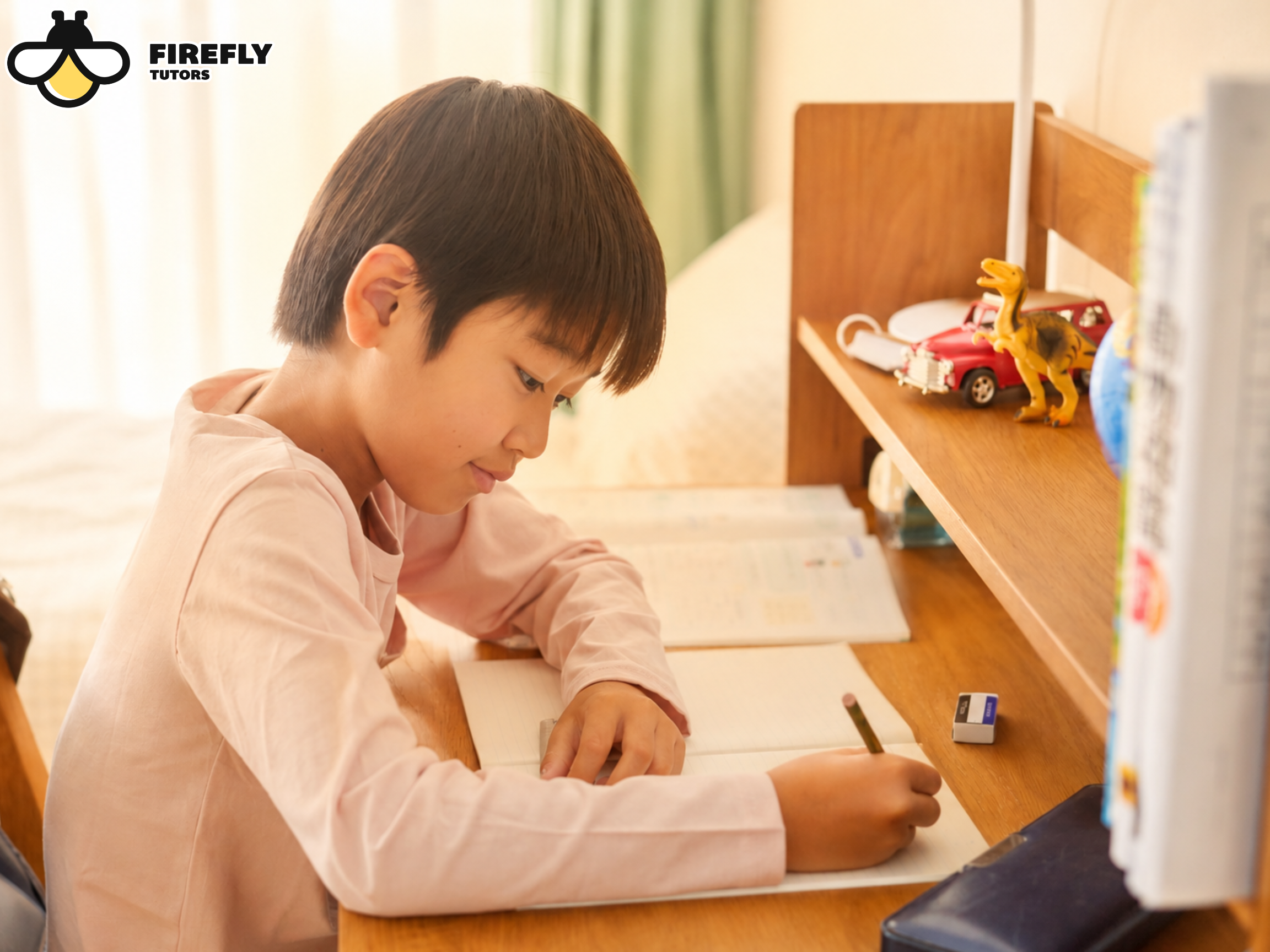 Young boy writing at his desk at home, practicing skills to avoid the summer slide